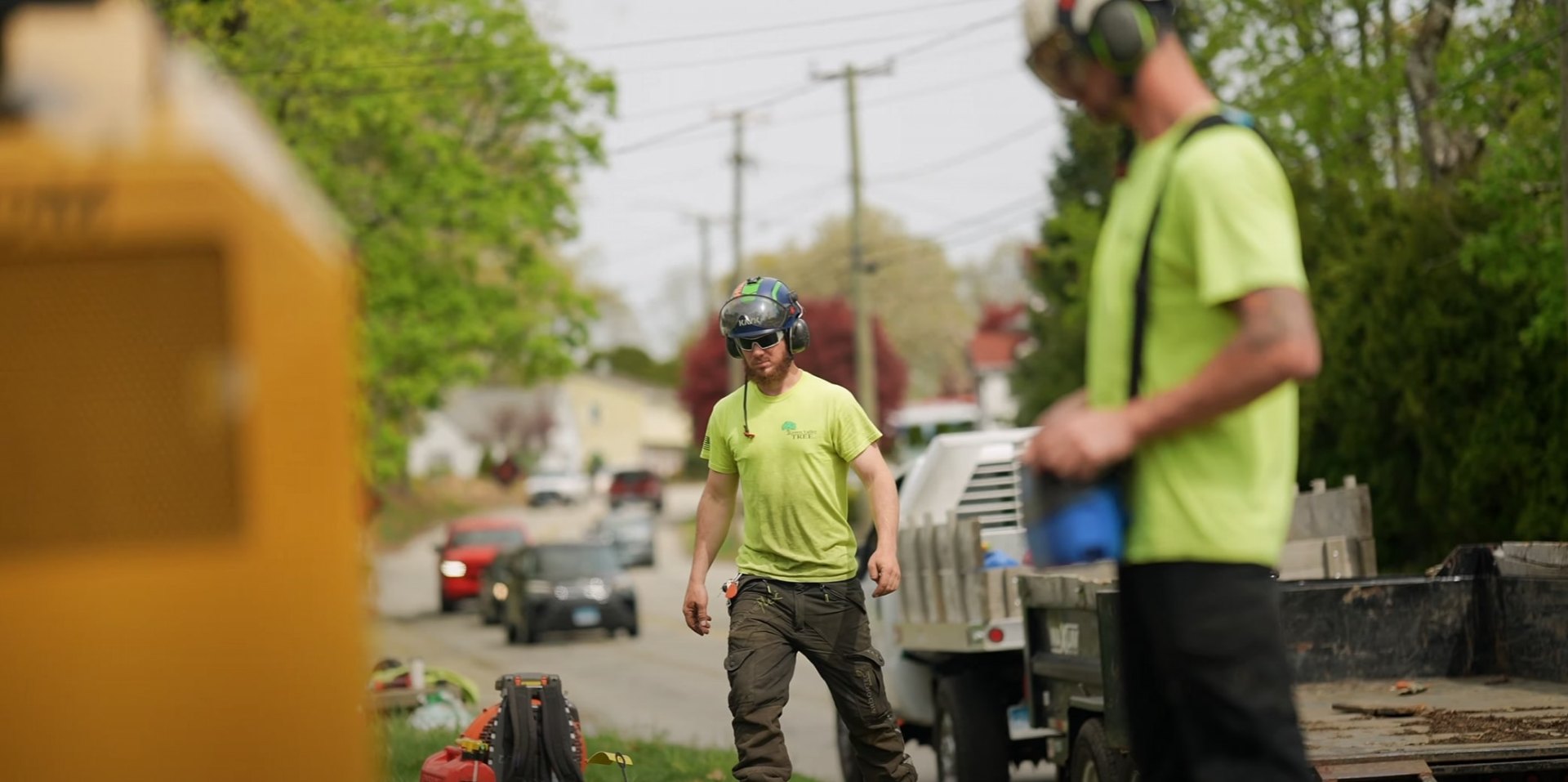 Safety-focused tree service professionals at work Professional tree service crew working safely with proper equipment and high-visibility gear