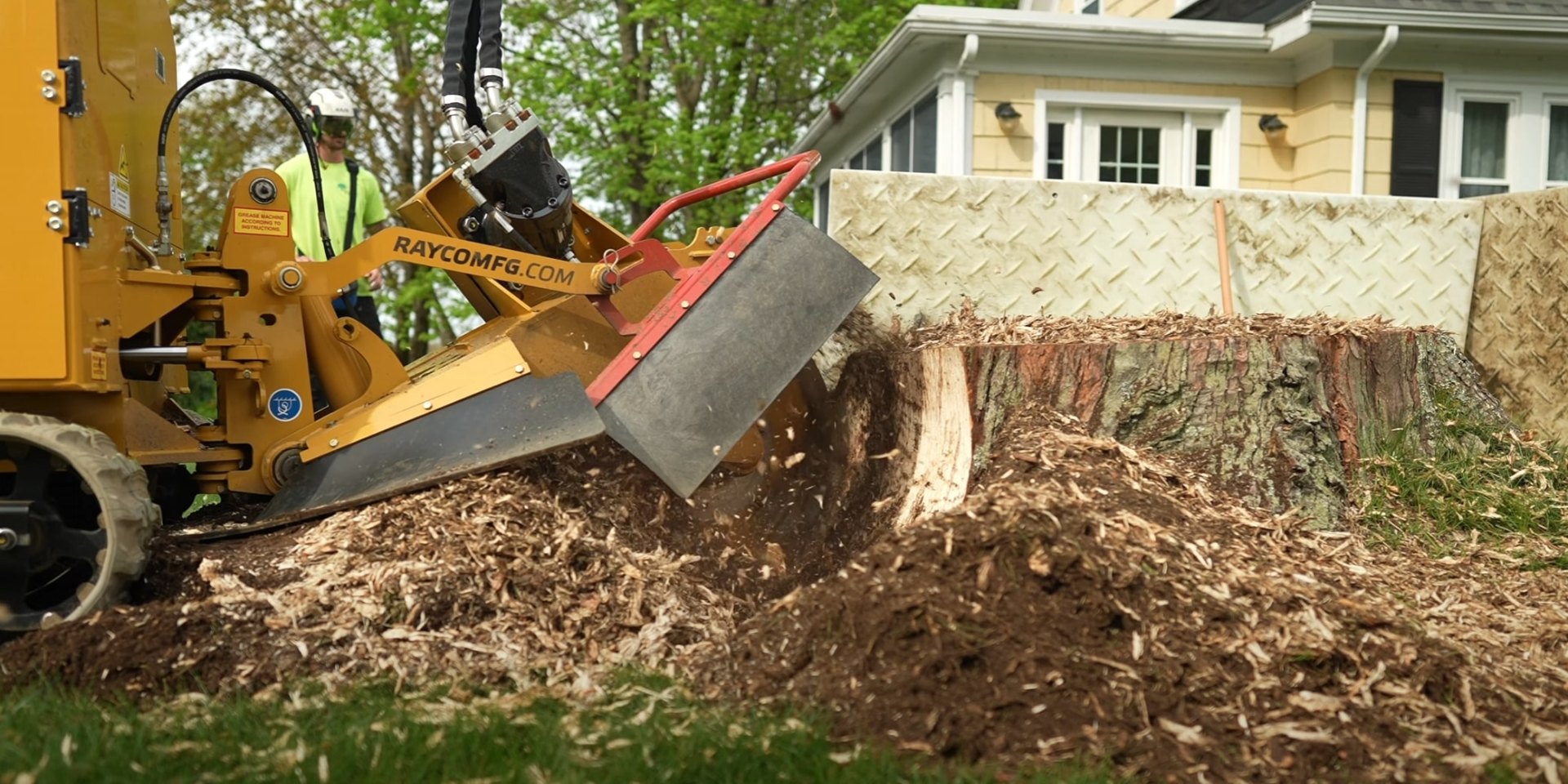 Efficient stump grinding for landscape restoration Professional stump grinding equipment removing large tree stump in residential yard